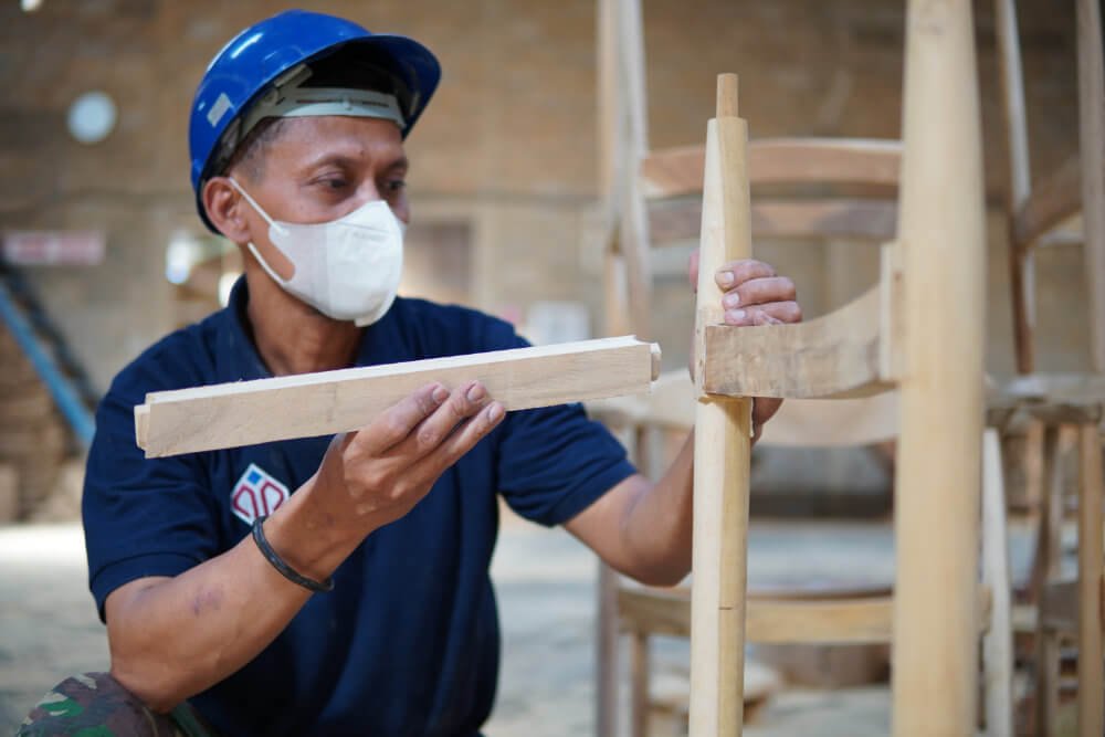 Craftsman assembling wooden chair frame using mortise and tenon joinery